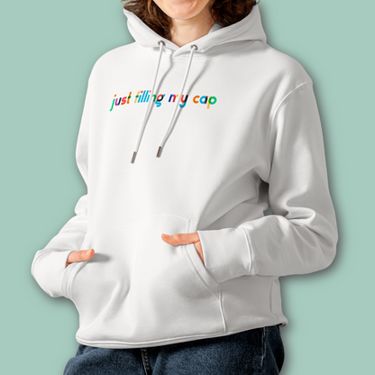 A female person wearing an organic hoodie in white by Lane Line Threads with colorful “just filling my cap” text on the chest, made from GOTS and OCS certified organic cotton.
