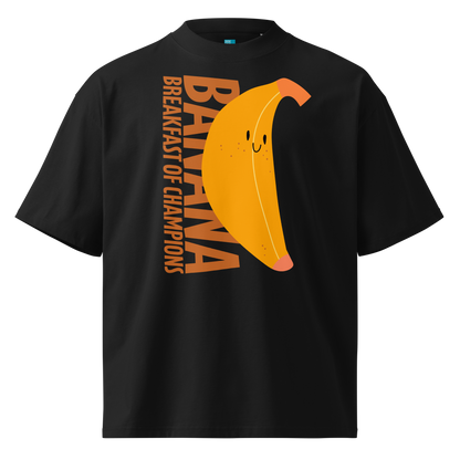 A black short-sleeve crewneck organic oversized t-shirt by Lane Line Threads featuring a graphic print of a smiling yellow banana with the text 'BANANA BREAKFAST OF CHAMPIONS' in brown.