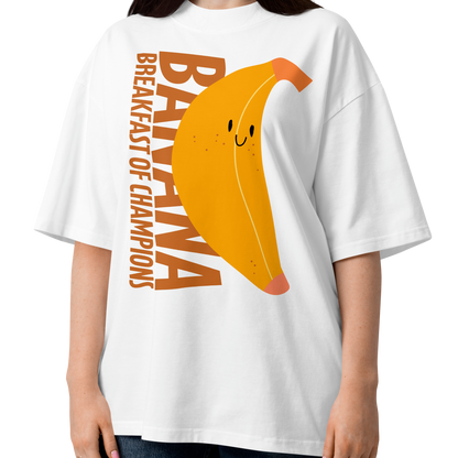 A woman modeling a white short-sleeve crewneck organic oversized t-shirt by Lane Line Threads featuring a graphic print of a smiling yellow banana with the text 'BANANA BREAKFAST OF CHAMPIONS' in brown.