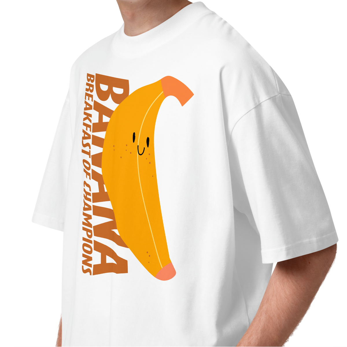 A young man with curly brown hair wearing a white short-sleeve crewneck organic oversized t-shirt by Lane Line Threads featuring a graphic print of a smiling yellow banana with the text 'BANANA BREAKFAST OF CHAMPIONS' in brown.