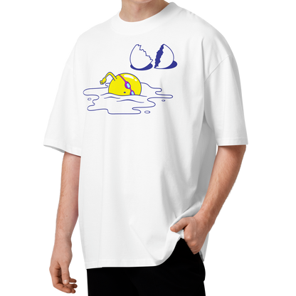 A young man with curly brown hair wearing a white short-sleeve crewneck organic oversized t-shirt by Lane Line Threads featuring a graphic print of a yellow cartoon egg yolk swimmer character breaking an egg on a white background.