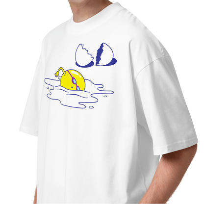 A young man with curly brown hair wearing a white short-sleeve crewneck organic oversized t-shirt by Lane Line Threads featuring a graphic print of a yellow cartoon egg yolk swimmer character breaking an egg on a white background.