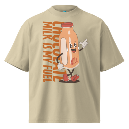 A beige short-sleeve crewneck organic oversized t-shirt by Lane Line Threads featuring a cartoon graphic of a vintage milk bottle character with the text 'CHOCOLATE MILK IS MY FUEL' printed vertically in orange and inspired by Katie Ledecky.