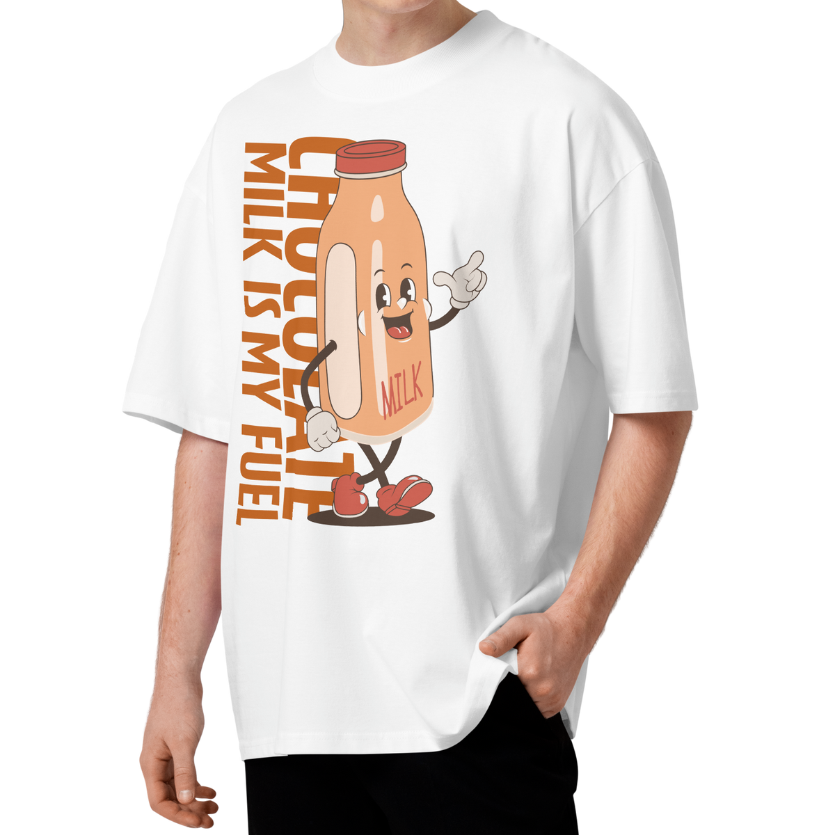 A young man with curly brown hair wearing a white short-sleeve crewneck organic oversized t-shirt by Lane Line Threads featuring a cartoon graphic of a vintage milk bottle character with the text 'CHOCOLATE MILK IS MY FUEL' printed vertically in orange and inspired by Katie Ledecky.