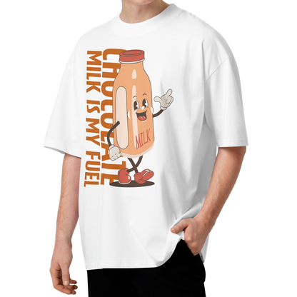 A young man with curly brown hair wearing a white short-sleeve crewneck organic oversized t-shirt by Lane Line Threads featuring a cartoon graphic of a vintage milk bottle character with the text 'CHOCOLATE MILK IS MY FUEL' printed vertically in orange and inspired by Katie Ledecky.
