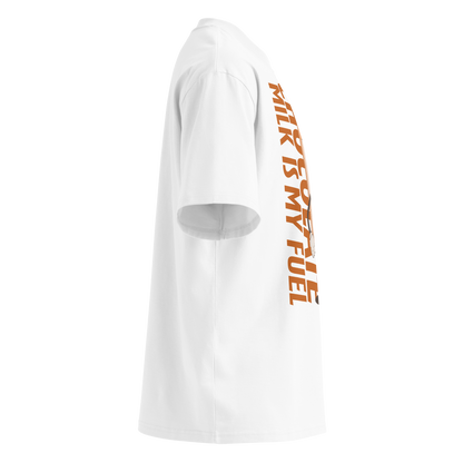 A white short-sleeve crewneck organic oversized t-shirt by Lane Line Threads featuring a cartoon graphic of a vintage milk bottle character with the text 'CHOCOLATE MILK IS MY FUEL' printed vertically in orange and inspired by Katie Ledecky, shown from the right side.