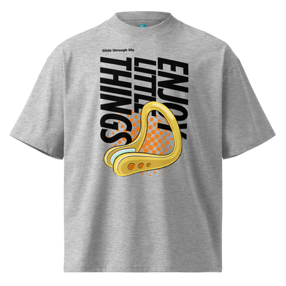 A grey short-sleeve crewneck organic oversized t-shirt by Lane Line Threads featuring a bold graphic print on the front. The design includes the text 'Enjoy Little Things' in black, a gold-colored swimming nose clip illustration, and a halftone pattern in orange.