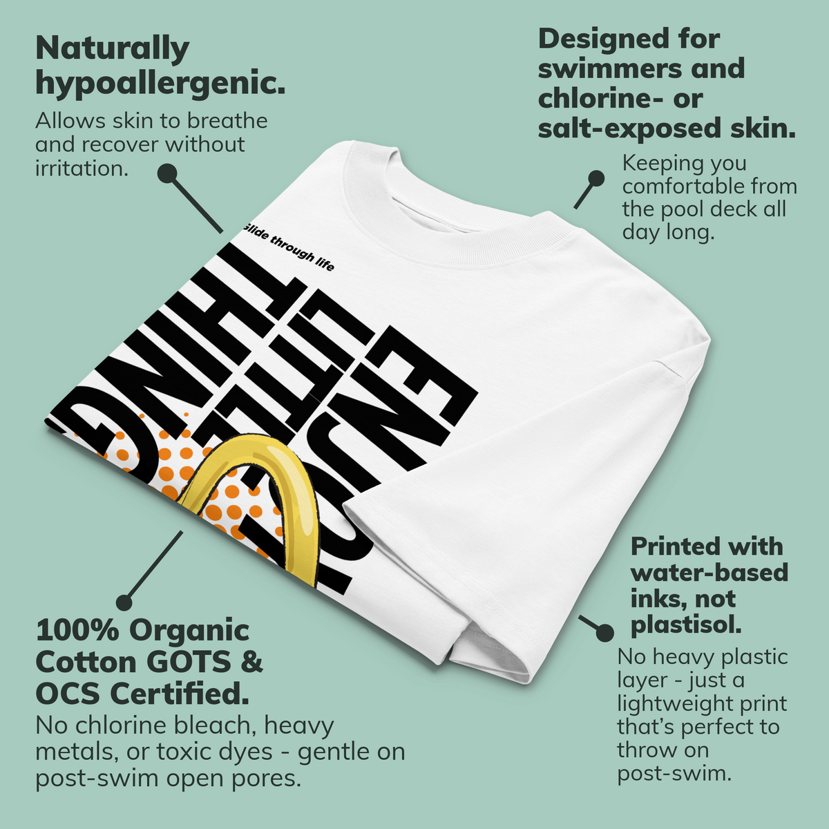 A folded white short-sleeve crewneck organic oversized t-shirt by Lane Line Threads featuring a bold graphic print on the front. The design includes the text 'Enjoy Little Things' in black, a gold-colored swimming nose clip illustration, and a halftone pattern in orange, with callouts featuring product benefits.
