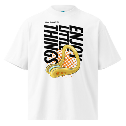 A white short-sleeve crewneck organic oversized t-shirt by Lane Line Threads featuring a bold graphic print on the front. The design includes the text 'Enjoy Little Things' in black, a gold-colored swimming nose clip illustration, and a halftone pattern in orange.