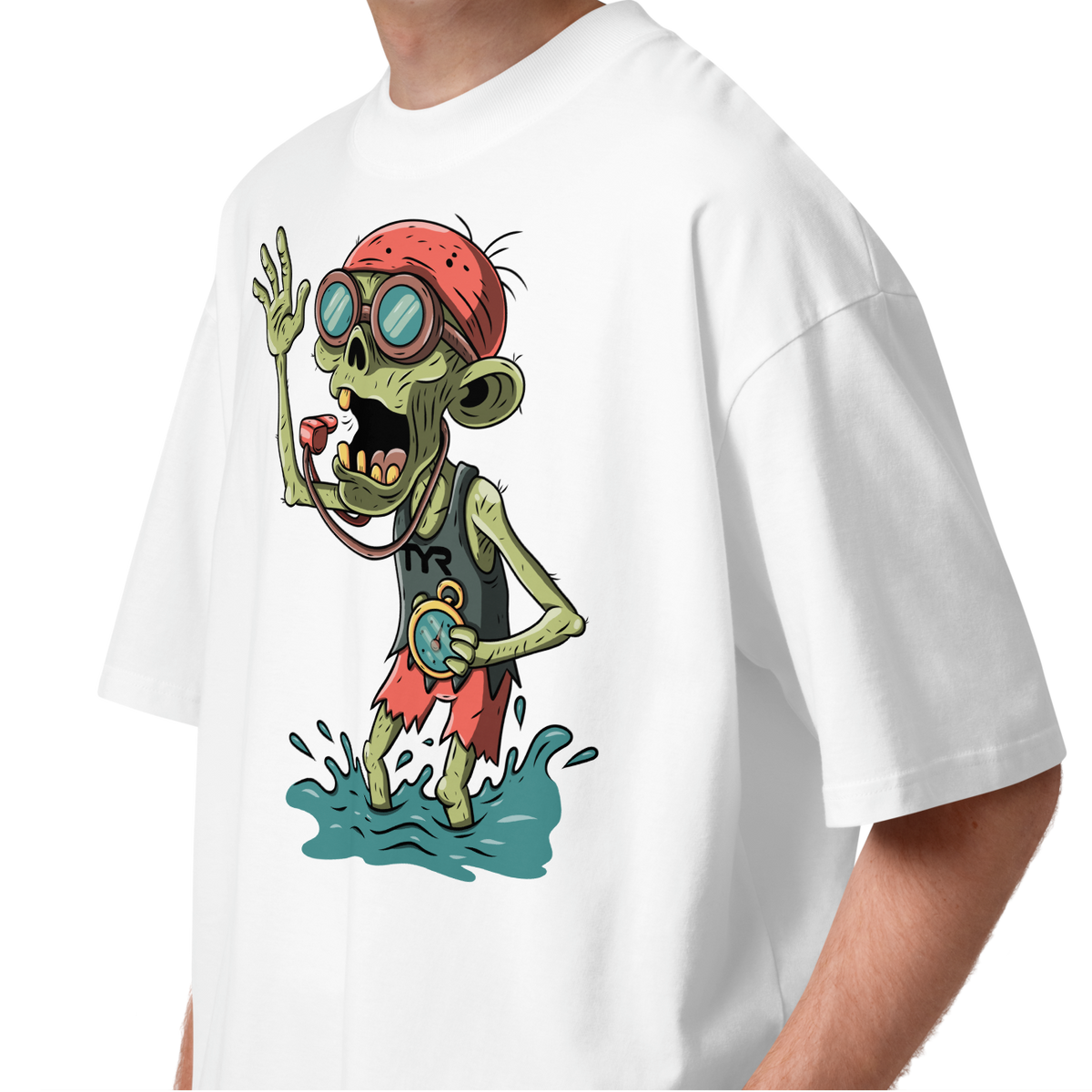 A young man with curly brown hair wearing a white short-sleeve crewneck Halloween organic oversized t-shirt by Lane Line Threads, featuring a colorful graphic of a zombie wearing a red swimming cap, swim goggles, and a black TYR tank, standing in splashing water.