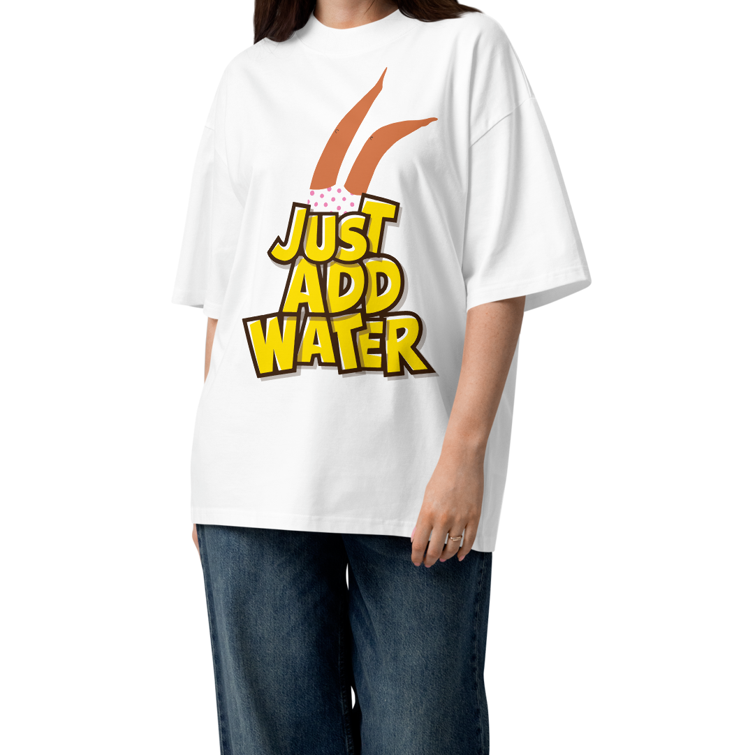 A woman modeling a white short-sleeve crewneck organic oversized t-shirt by Lane Line Threads featuring a graphic print of woman legs wearing a pink polka-dot swimsuit, with the text 'JUST ADD WATER' in bold yellow letters with black outlines.