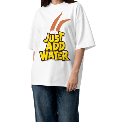 A woman modeling a white short-sleeve crewneck organic oversized t-shirt by Lane Line Threads featuring a graphic print of woman legs wearing a pink polka-dot swimsuit, with the text 'JUST ADD WATER' in bold yellow letters with black outlines.
