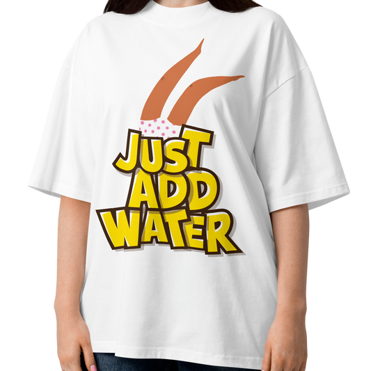 A woman wearing a white short-sleeve crewneck organic oversized t-shirt by Lane Line Threads featuring a graphic print of woman legs wearing a pink polka-dot swimsuit, with the text 'JUST ADD WATER' in bold yellow letters with black outlines.