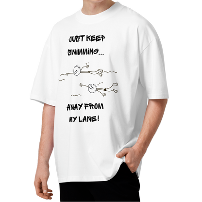 A young man with curly brown hair wearing an organic oversized t-shirt in white with a stick-figure drawing of two swimmers and the text Just keep swimming away from my lane by Lane Line Threads.