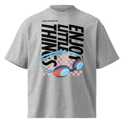 Organic oversized t-shirt in grey with colorful swim goggles, bold “Enjoy Little Things” lettering, and “Glide Through Life” graphic by Lane Line Threads.