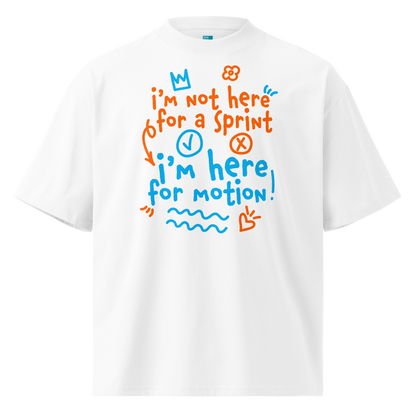 A white short-sleeve crewneck organic oversized t-shirt by Lane Line Threads with a colorful graphic print on the chest. The graphic features the text 'I'm not here for a sprint I'm here for motion!' in orange and blue handwritten-style lettering, accompanied by small doodles of a clock, a stop sign, wavy lines, and a heart.