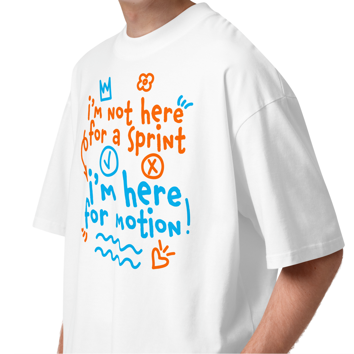 A young man with curly brown hair wearing a white short-sleeve crewneck organic oversized t-shirt by Lane Line Threads with a colorful graphic print on the chest. The graphic features the text 'I'm not here for a sprint I'm here for motion!' in orange and blue handwritten-style lettering, accompanied by small doodles of a clock, a stop sign, wavy lines, and a heart.