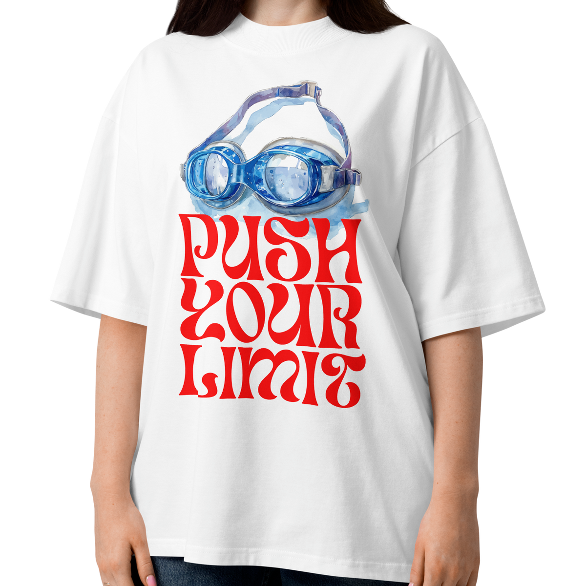 A woman wearing a white organic oversized t-shirt by Lane Line Threads with a blue swim goggles and red 'PUSH YOUR LIMIT' text design, paired with blue jeans, against a plain white background.