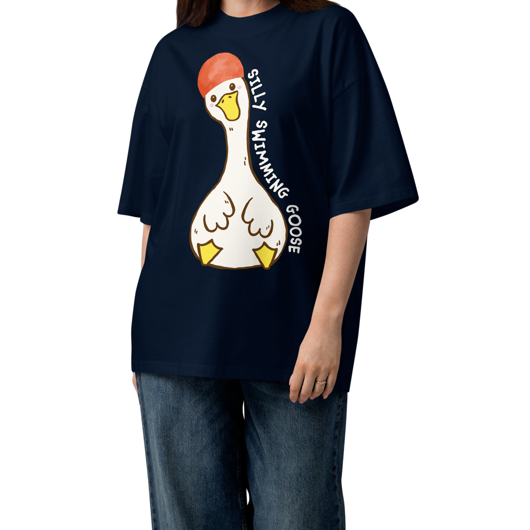 A woman modeling a navy blue short-sleeve organic oversized t-shirt by Lane Line Threads featuring a cartoon graphic of a white swimming goose wearing a red swim cap, with the text 'SILLY SWIMMING GOOSE' printed vertically alongside it.
