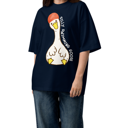 A woman modeling a navy blue short-sleeve organic oversized t-shirt by Lane Line Threads featuring a cartoon graphic of a white swimming goose wearing a red swim cap, with the text 'SILLY SWIMMING GOOSE' printed vertically alongside it.