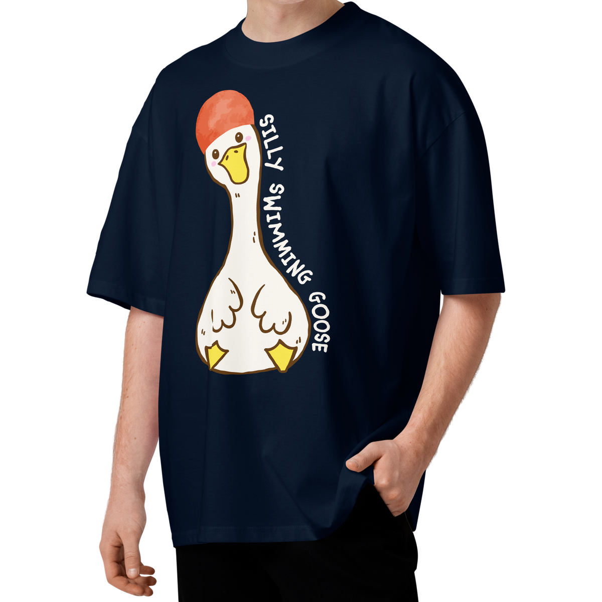A young man wearing a navy blue short-sleeve organic oversized t-shirt by Lane Line Threads featuring a cartoon graphic of a white swimming goose wearing a red swim cap, with the text 'SILLY SWIMMING GOOSE' printed vertically alongside it.