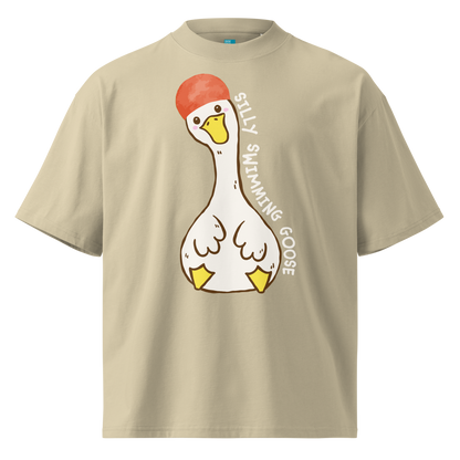A beige short-sleeve organic oversized t-shirt by Lane Line Threads featuring a cartoon graphic of a white swimming goose wearing a red swim cap, with the text 'SILLY SWIMMING GOOSE' printed vertically alongside it.