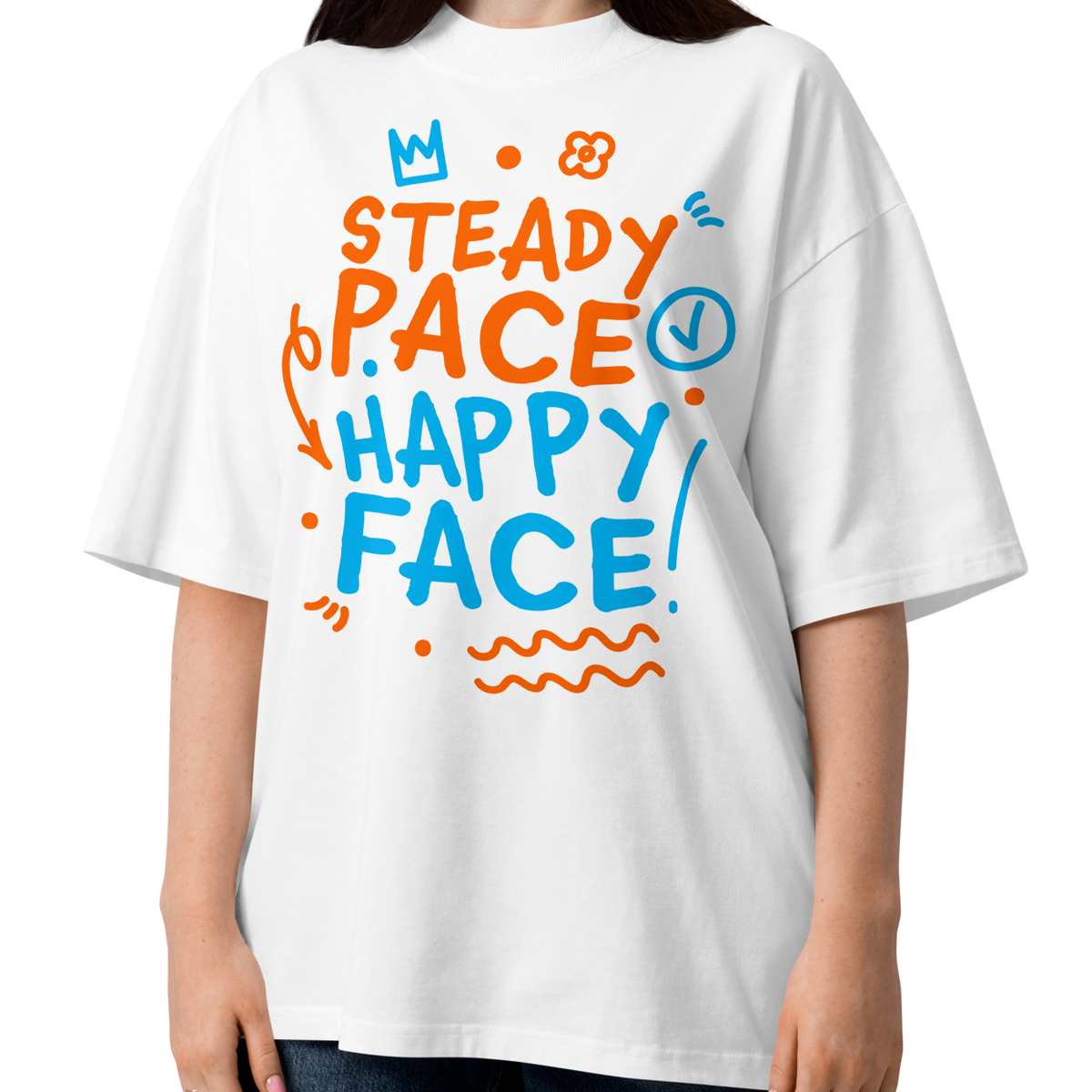 A woman modeling a white short-sleeve crewneck organic oversized t-shirt by Lane Line Threads featuring a colorful graphic print on the front with the words 'STEADY PACE HAPPY FACE' in orange and blue hand-drawn lettering.
