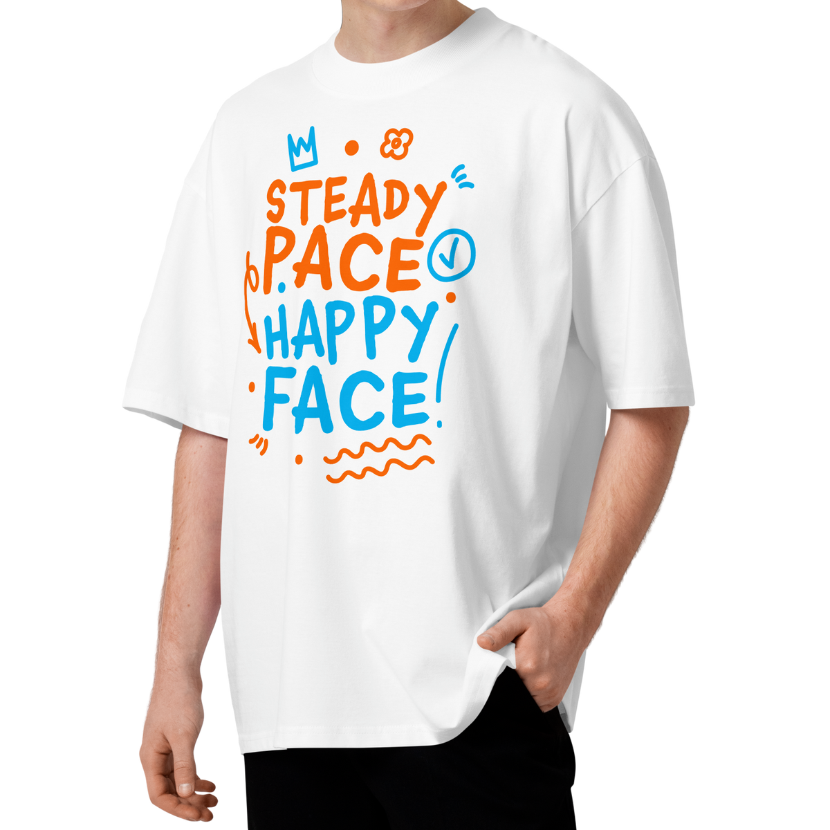 A young man with curly brown hair wearing a white short-sleeve crewneck organic oversized t-shirt by Lane Line Threads featuring a colorful graphic print on the front with the words 'STEADY PACE HAPPY FACE' in orange and blue hand-drawn lettering.