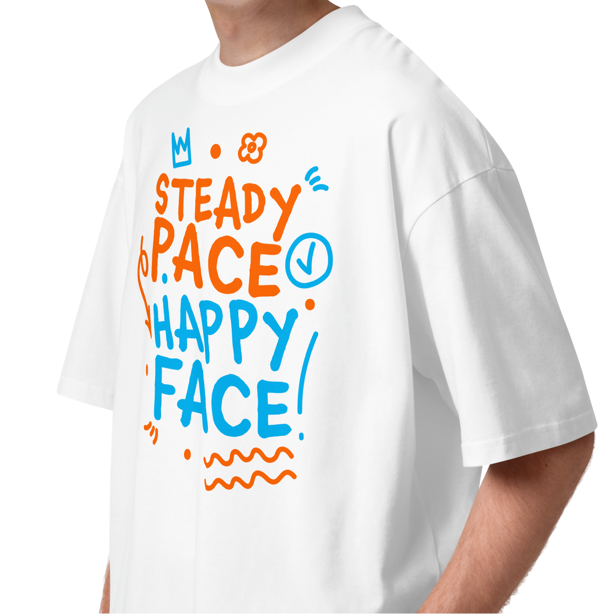 A young man with curly brown hair wearing a white short-sleeve crewneck organic oversized t-shirt by Lane Line Threads featuring a colorful graphic print on the front with the words 'STEADY PACE HAPPY FACE' in orange and blue hand-drawn lettering.