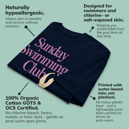 A navy blue organic oversized t-shirt with pink and white text reading 'Sunday Swimming Club' is shown on a light teal background with callout text describing product features and benefits.