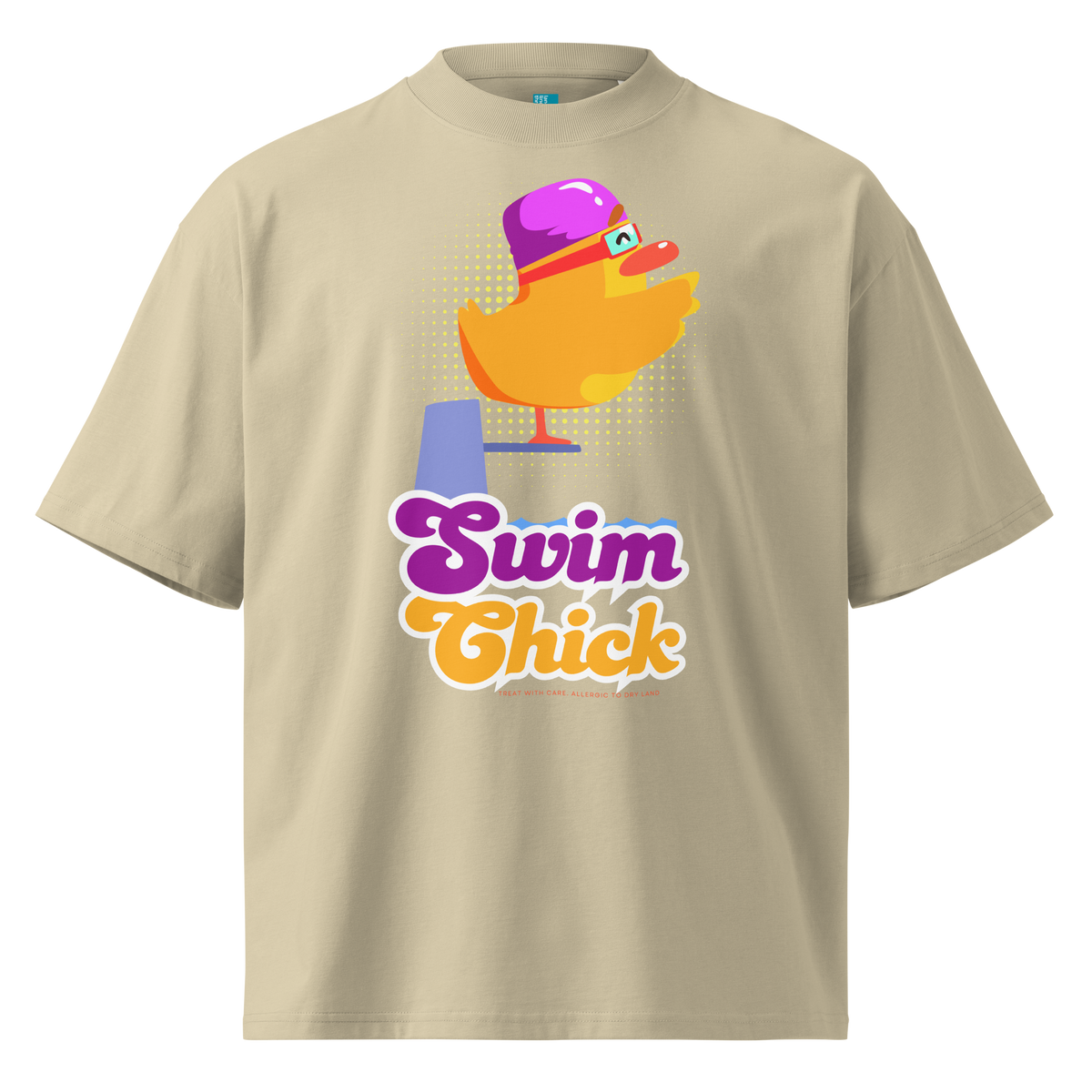 A beige short-sleeve crewneck organic oversized t-shirt by Lane Line Threads featuring a colorful graphic of a yellow duck wearing a purple swim cap and goggles, with the text 'Swim Chick' printed below in purple and orange.