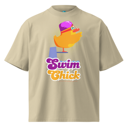 A beige short-sleeve crewneck organic oversized t-shirt by Lane Line Threads featuring a colorful graphic of a yellow duck wearing a purple swim cap and goggles, with the text 'Swim Chick' printed below in purple and orange.