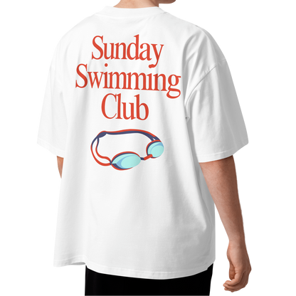 A person shown from the back wearing a white organic oversized t-shirt with a red 'Sunday Swimming Club' text graphic and a small red-and-blue swim goggles illustration on the back.