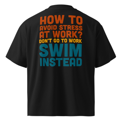 A black short-sleeve organic oversized t-shirt by Lane Line Threads, shown from the back, featuring a bold typographic graphic in orange, yellow, and teal that reads, 'HOW TO AVOID STRESS AT WORK? DON'T GO TO WORK SWIM INSTEAD'.