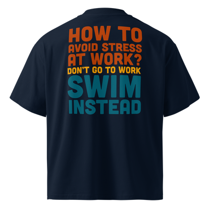 a navy short-sleeve organic oversized t-shirt by Lane Line Threads, shown from the back, featuring a bold typographic graphic in orange, yellow, and teal that reads, 'HOW TO AVOID STRESS AT WORK? DON'T GO TO WORK SWIM INSTEAD'.