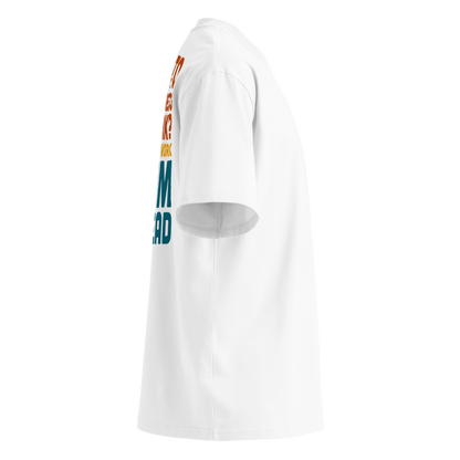 White short-sleeve organic oversized t-shirt by Lane Line Threads, featuring a bold typographic graphic in orange, yellow, and teal that reads, 'HOW TO AVOID STRESS AT WORK? DON'T GO TO WORK SWIM INSTEAD', shown from the right side.