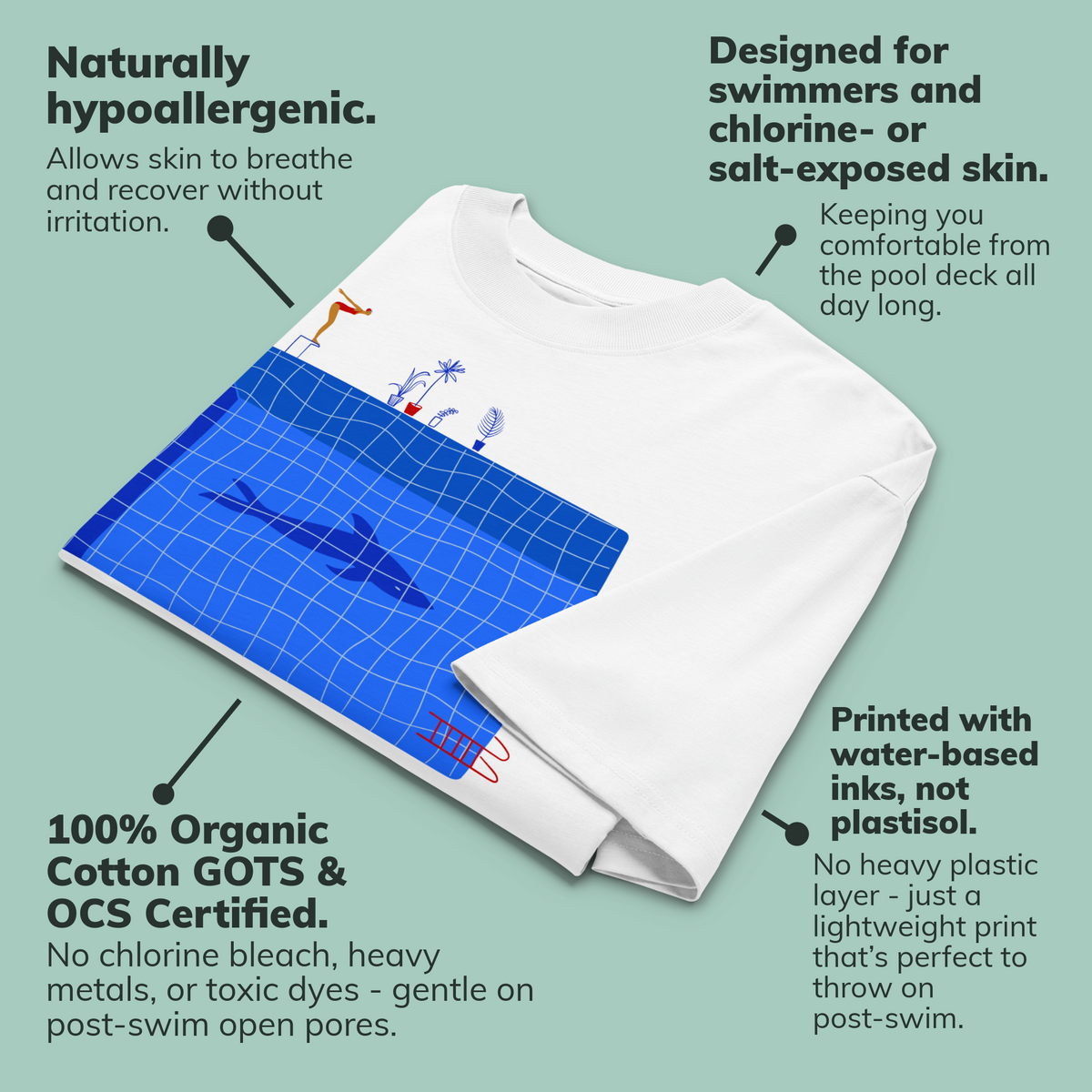 A folded white short-sleeve crewneck organic oversized t-shirt by Lane Line Threads for swimmers featuring a graphic print of a blue swimming pool with a diving board, a diver, plants, and a shark on the front shown on a pale green background with callout text describing product benefits and materials.