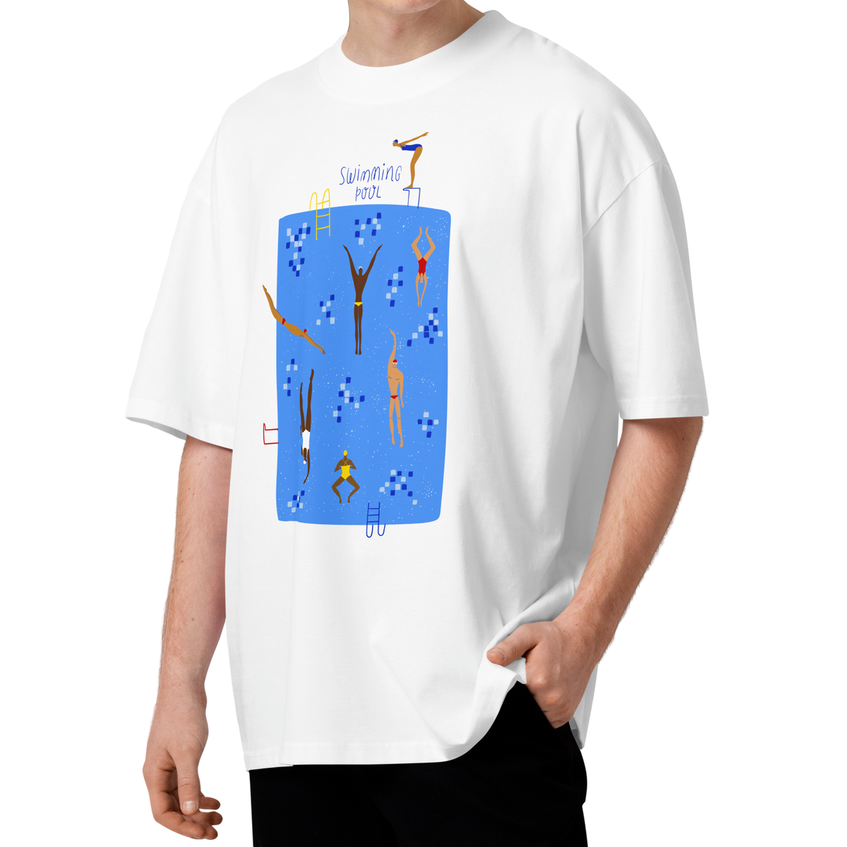 A young man with curly brown hair wearing a white short-sleeve crewneck organic oversized t-shirt by Lane Line Threads featuring a colorful graphic print of a swimming pool with various stylized swimmers and divers on a clean background.