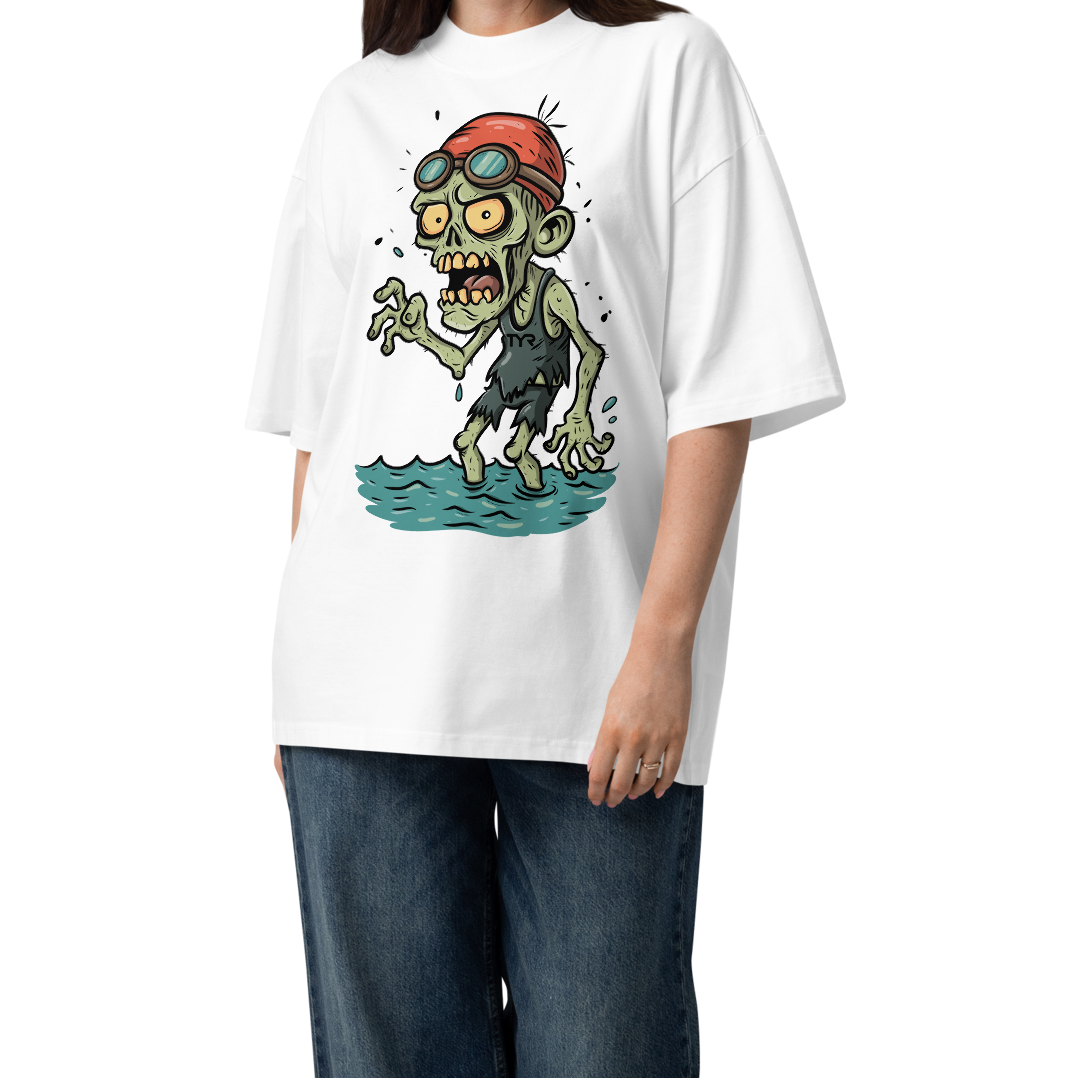 A woman modeling a white short-sleeve crewneck organic oversized t-shirt by Lane Line Threads, featuring a cartoon graphic of a zombie wearing a red swim cap and goggles, standing in water.
