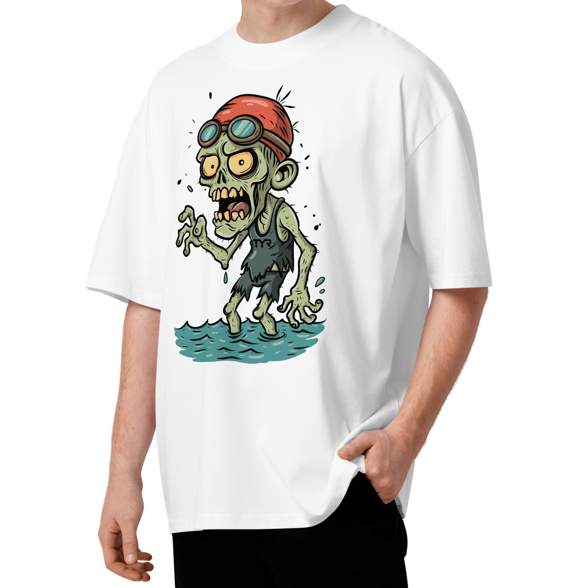A young man with curly brown hair wearing a white short-sleeve crewneck organic oversized t-shirt by Lane Line Threads, featuring a cartoon graphic of a zombie wearing a red swim cap and goggles, standing in water.