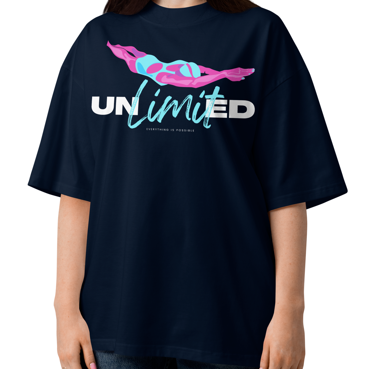 A woman modeling a navy blue short-sleeve organic oversized t-shirt by Lane Line Threads with a graphic on the chest featuring a pink and blue female swimmer silhouette above the text 'UNlimited' in white and light blue.