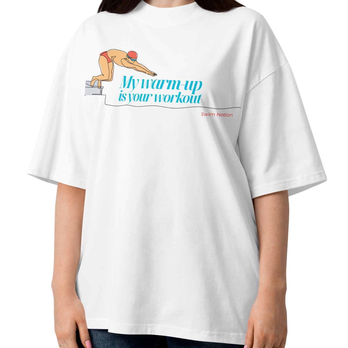 A woman modeling a white short-sleeve crewneck organic oversized t-shirt by Lane Line Threads featuring a graphic of a swimmer on a diving block with the text 'My warm-up is your workout' in blue and 'Swim Nation' in red below, paired with dark blue jeans against a plain white background.