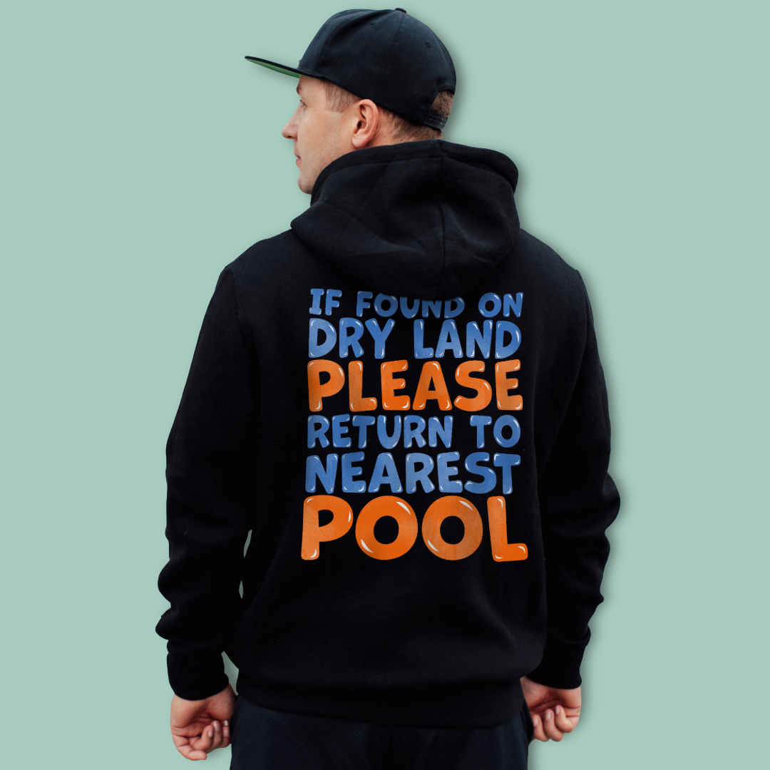Person wearing a black organic post swim hoodie with colorful swimmers' humor text on the back against a light green background