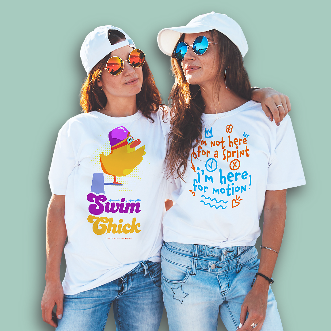Two people wearing white post swim organic shirts with colorful swim-themed text and graphics on a light green background