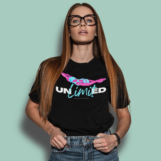 Woman wearing an organic black post swim shirt with 'UNLIMITED' design on a light green background