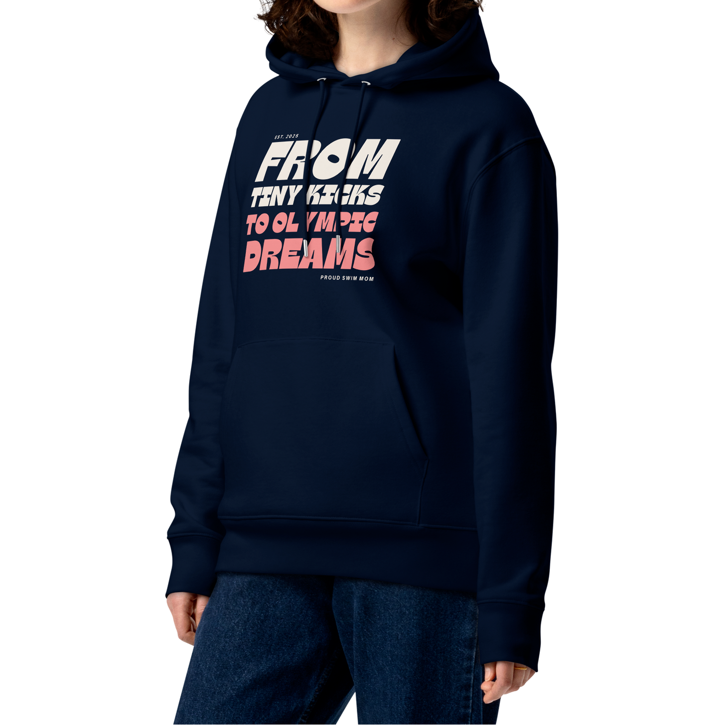 Person wearing a navy swim mom organic hoodie with “From Tiny Kicks to Olympic Dreams – Proud Swim Mom” text in white and pink; 100% organic certified cotton for eco‑conscious swim families.