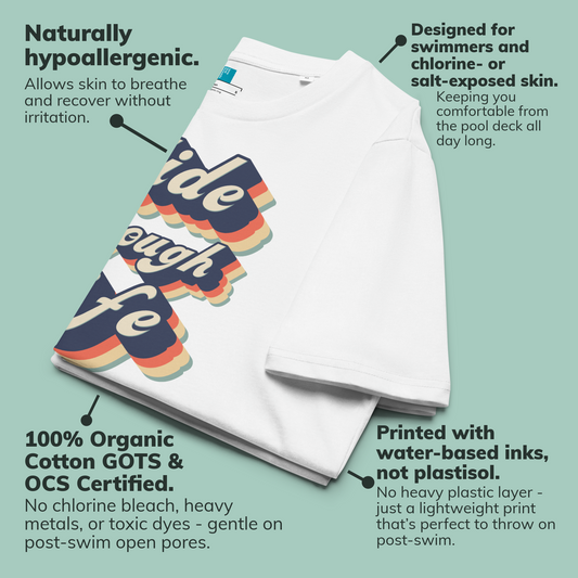 White organic swim shirt with colorful graphic design on a light green background, featuring text about product features.