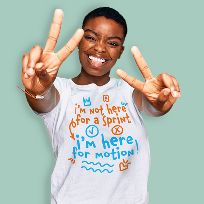 Person wearing an organic swim shirt with a colorful graphic and text, making peace signs against a light green background