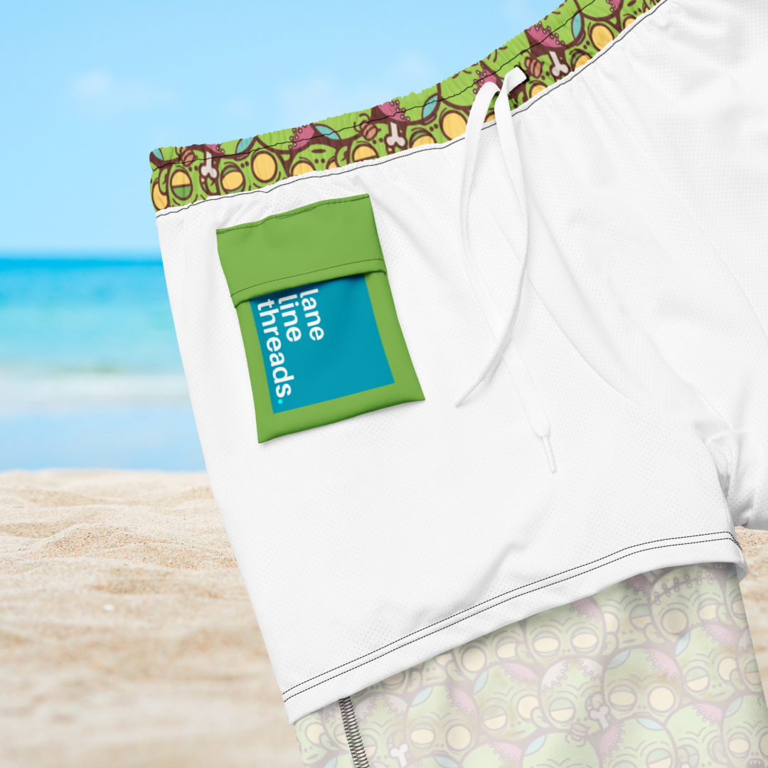 Inner side close-up of an organic swim trunks with green pocket and 'lane threads' label on a beach background