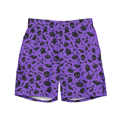 A pair of purple organic swim trunks with a repeating pattern of black Halloween-themed graphics including ghosts, pumpkins, skulls, bats, and bones. 